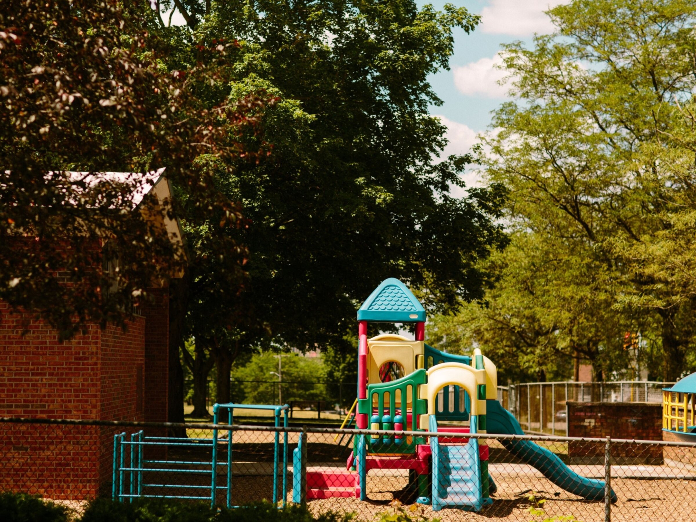 The playground of Post-Franklin sits outside the building under trees