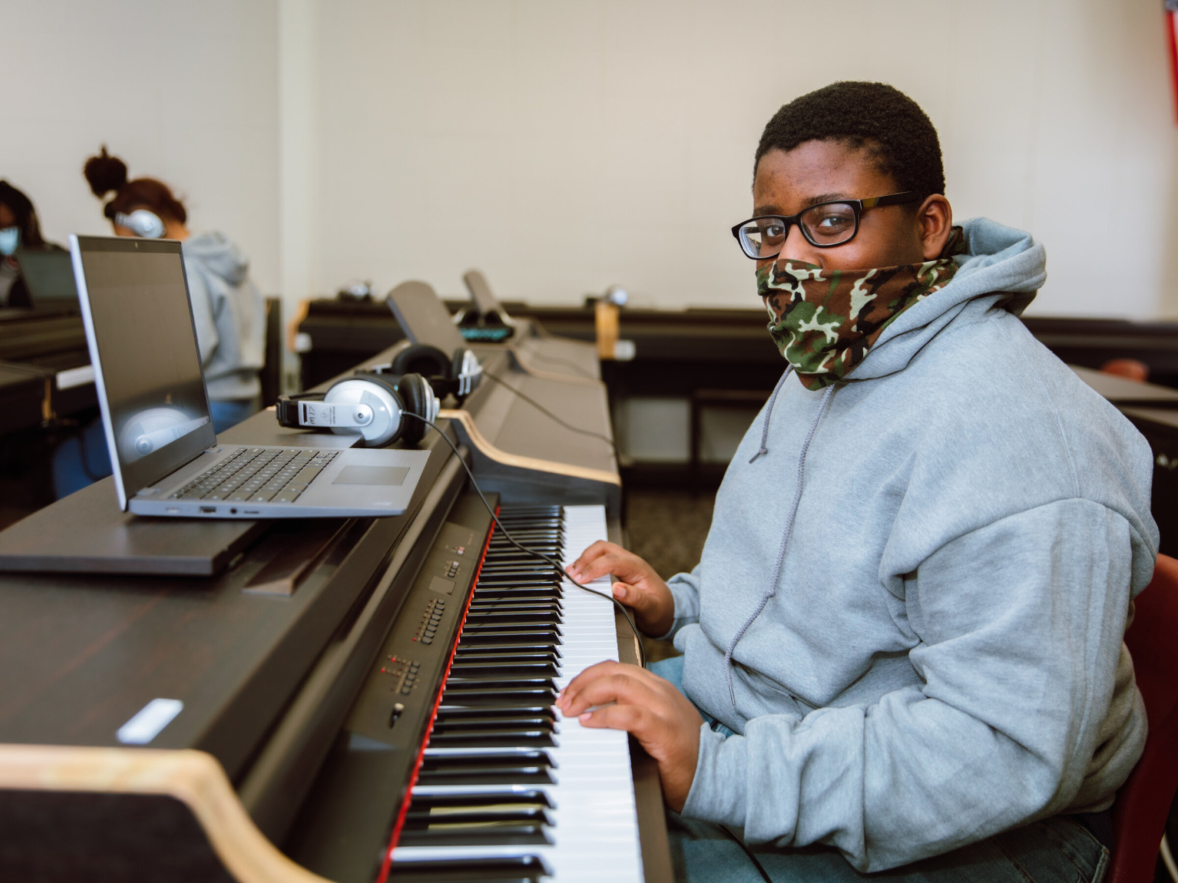 student in mask at keyboard